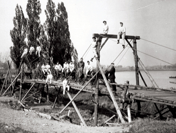 Un groupe d'hommes debout sur un pont en bois au Musée canadien de la guerre à Ottawa.