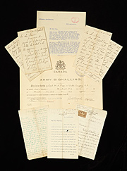 A collection of old letters and papers set against a black background.