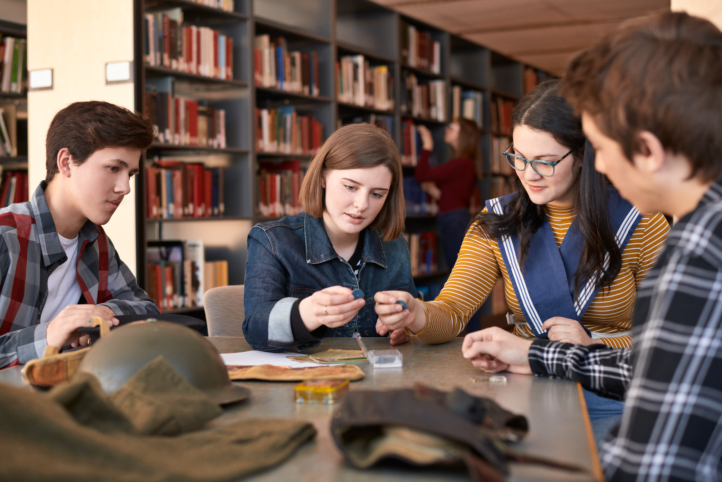 A group of people sitting around a table looking at items from a Discovery Box.