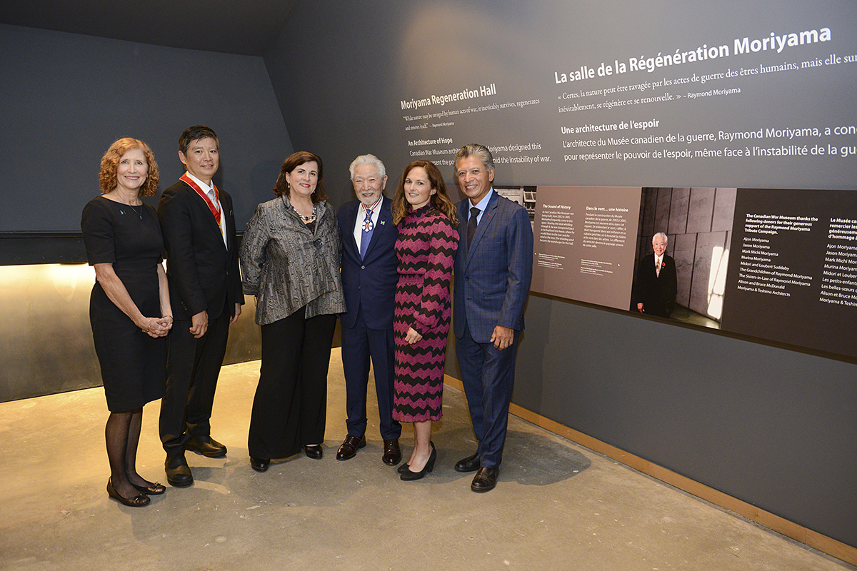 Un groupe de personnes posant devant une exposition murale au Musée canadien de la guerre à Ottawa.