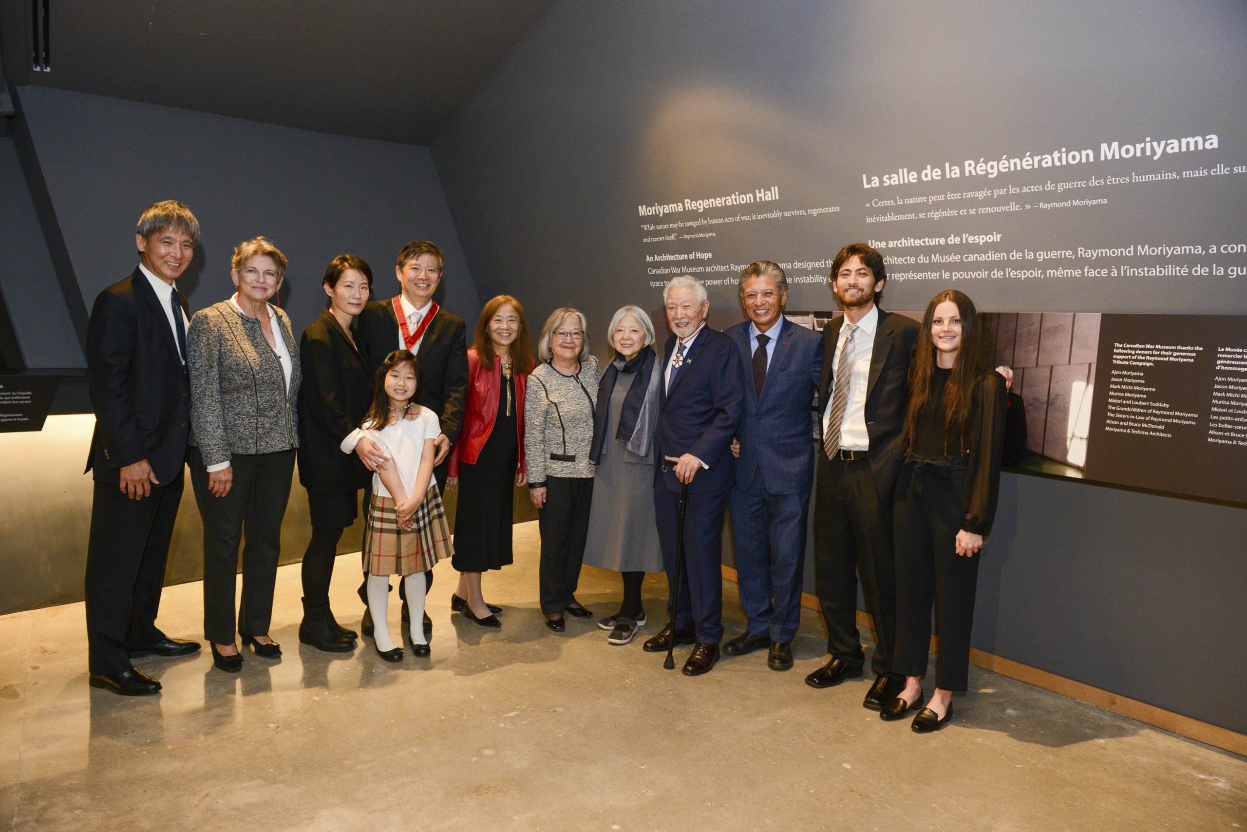 Un groupe de personnes posant pour une photo devant le Musée canadien de la guerre à Ottawa.