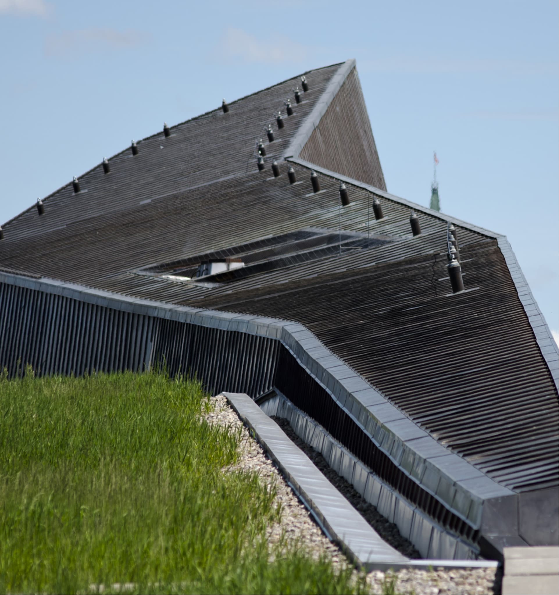 Un bâtiment à Ottawa, le Musée canadien de la guerre, avec un toit en métal et en herbe.