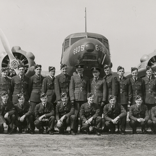 Un groupe d'hommes posant devant un avion au Musée canadien de la guerre à Ottawa.