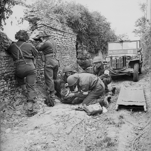 Un groupe de soldats sont allongés sur un mur près d'une jeep au Musée canadien de la guerre à Ottawa.