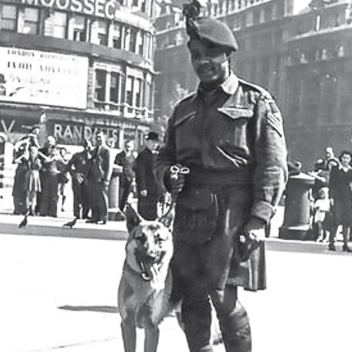 Un homme en kilt debout à côté d'un chien au Musée canadien de la guerre à Ottawa.