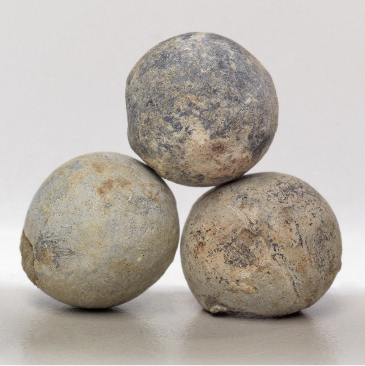 Trois boules de pierre sur une surface blanche au Musée canadien de la guerre à Ottawa.