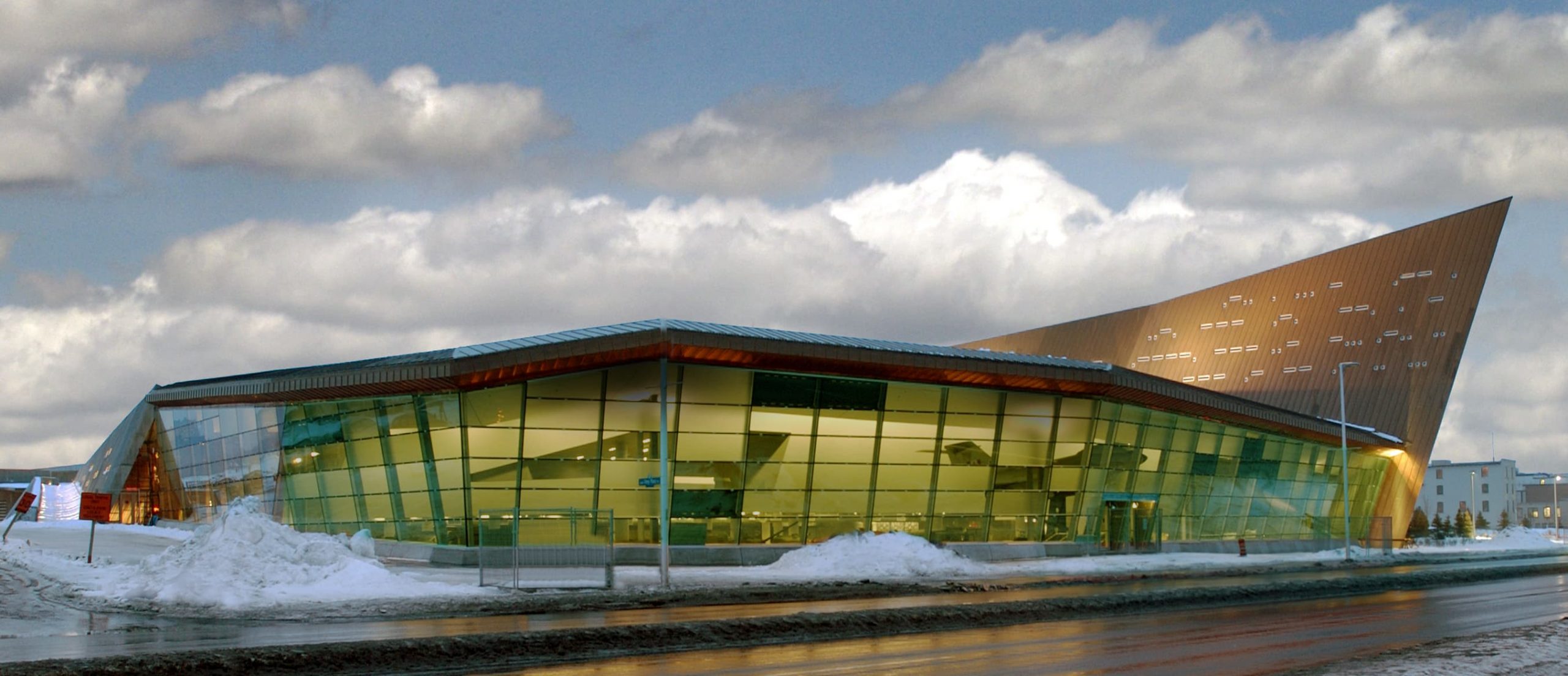 Le Musée canadien de la guerre, situé à Ottawa, présente un bâtiment avec un toit vert et de la neige au sol.