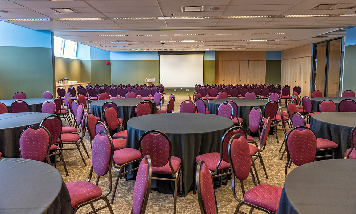 Une grande salle de conférence avec tables et chaises située à Ottawa, à proximité du Musée canadien de la guerre.