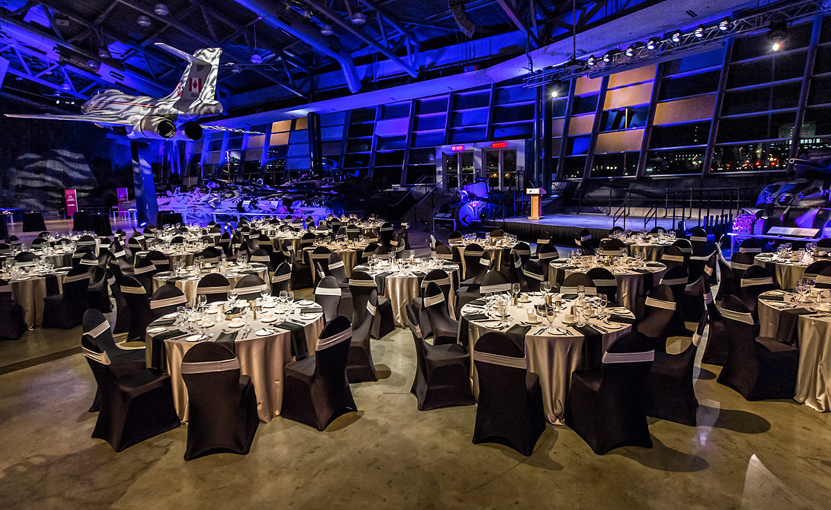 Une grande salle du Musée canadien de la guerre à Ottawa, avec des tables et des chaises installées pour un dîner.