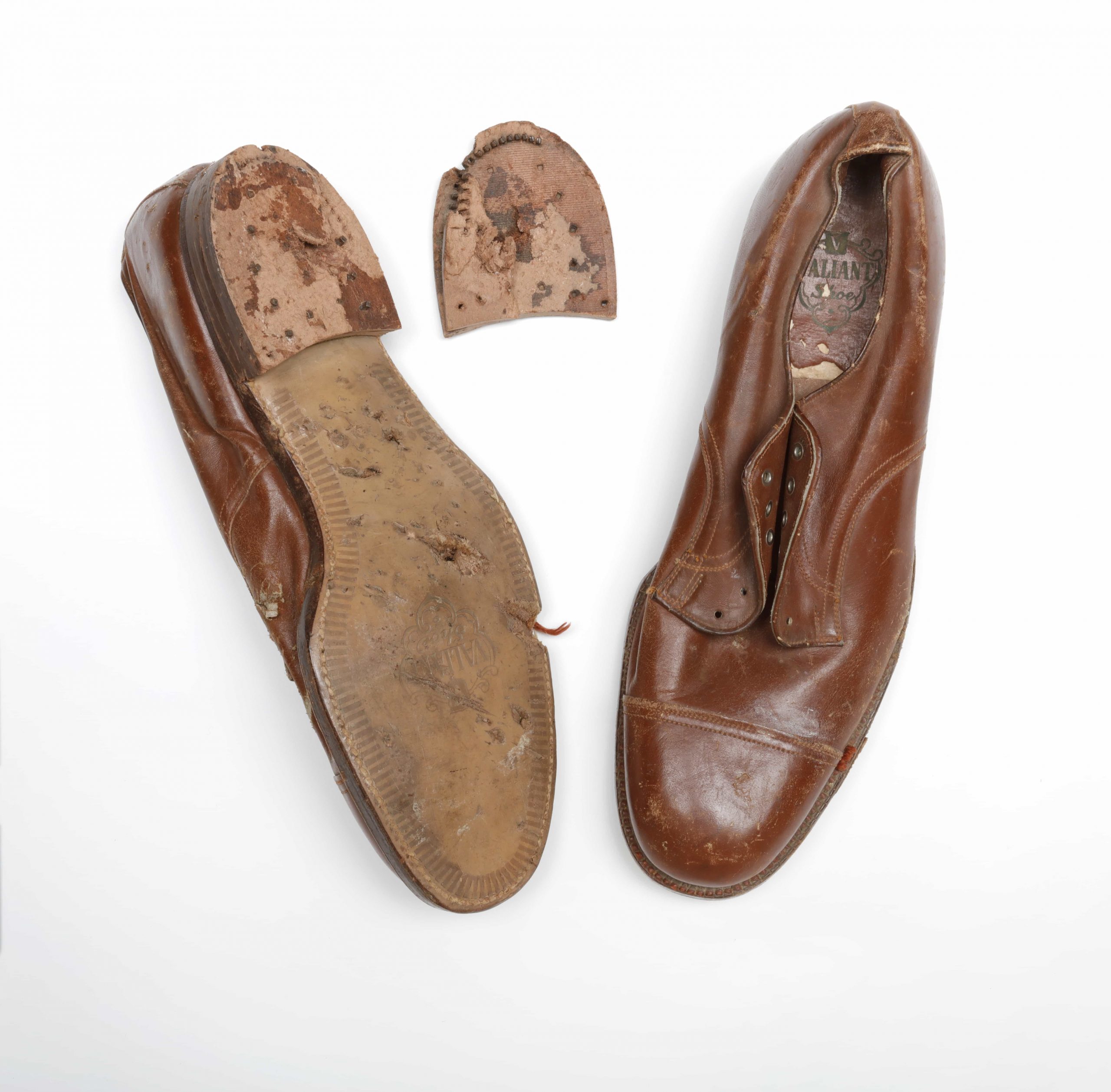 Une paire de chaussures marron avec un trou dans la semelle, située à Ottawa au Musée canadien de la guerre.