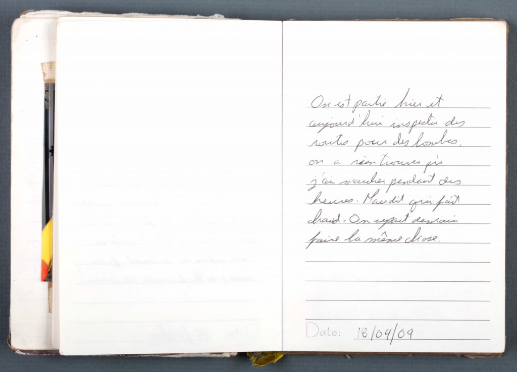 Un cahier ouvert avec une écriture manuscrite et un crayon au Musée canadien de la guerre à Ottawa.