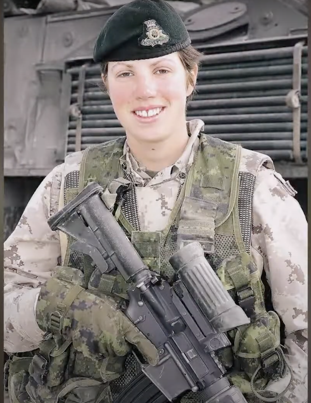 Une femme tenant un fusil devant un véhicule militaire au Musée canadien de la guerre à Ottawa.