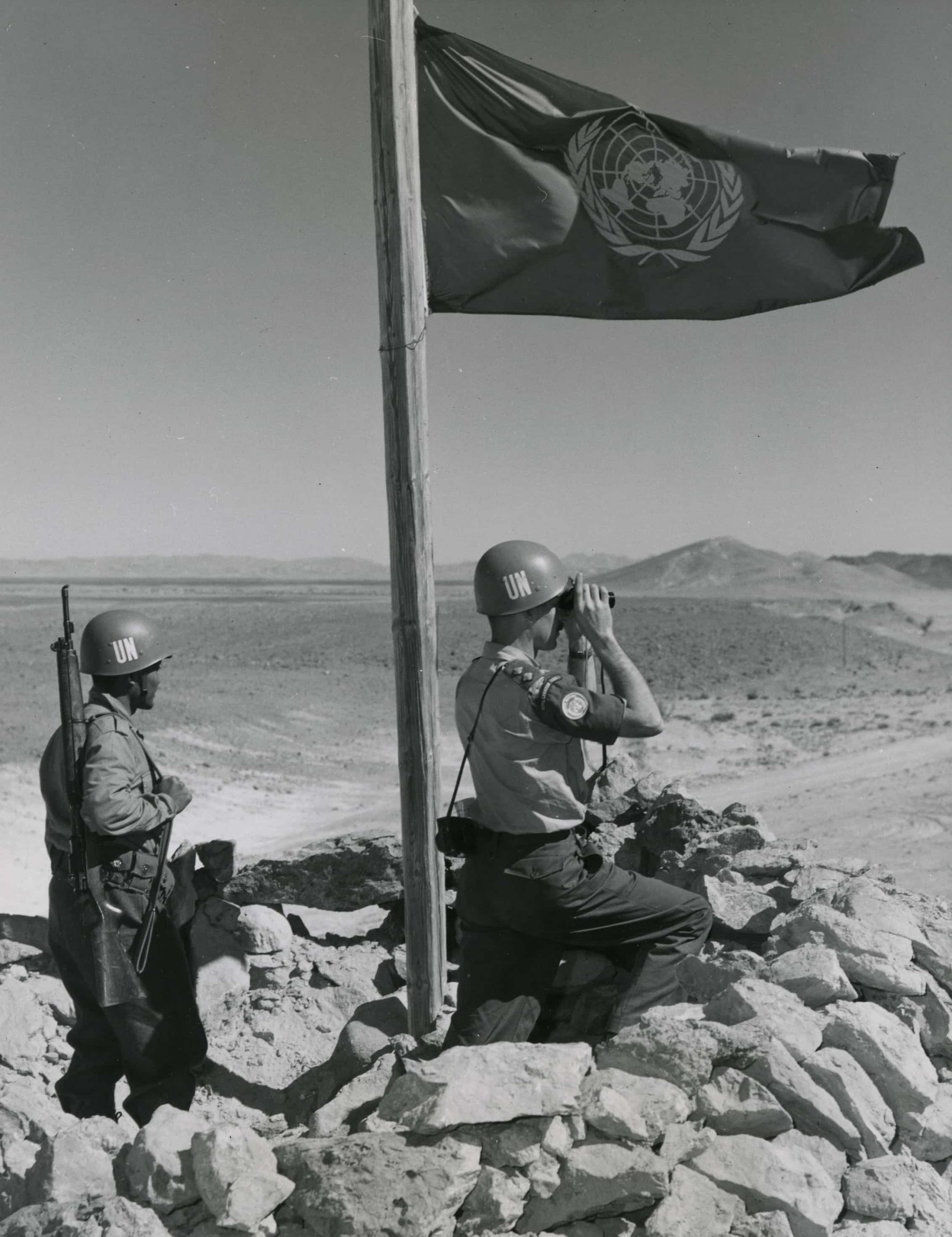 Deux soldats regardent un drapeau à Ottawa.