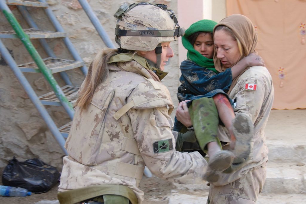 Une femme en uniforme militaire tient un enfant dans ses bras au Musée canadien de la guerre à Ottawa.