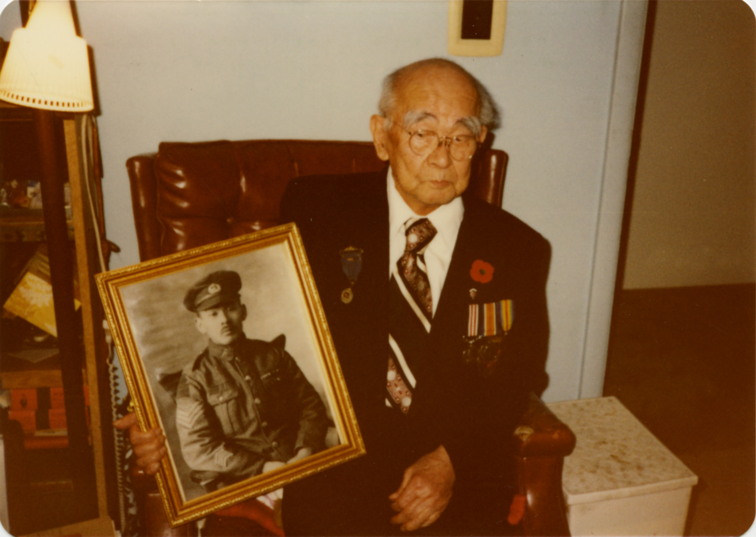 Un homme plus âgé tenant une photo d’un militaire au Musée canadien de la guerre à Ottawa.